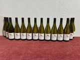 six bottles of white wine lined up on a table