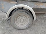 a flat tire on a flatbed truck parked in the dirt