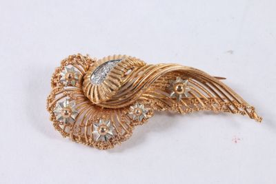 une image d'une broche en or et diamants sur une surface blanche