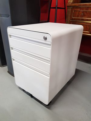 a white filing cabinet sitting on the floor next to a red chair