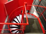 a red spiral staircase going up the side of a building