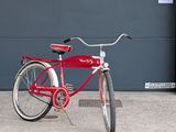 a red bicycle that is parked in front of a garage