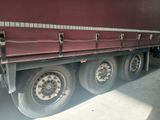 a red semi truck parked in a garage next to a building