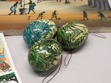 three decorative eggs sitting on a table next to a book