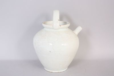 a white vase with a handle sitting on a table