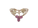 un gros plan d'une broche en diamants roses et blancs sur fond blanc