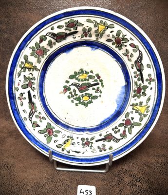 une assiette bleue et blanche décorée d'oiseaux et de fleurs
