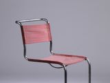une chaise rouge posée sur un sol blanc