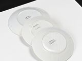 three white plates sitting on top of a piece of paper