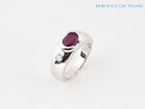 a close up of a ring with a ruby stone on it