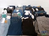 several pairs of jeans are stacked on top of each other on a table