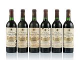 four bottles of wine are lined up on a white surface