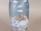 a vase with a mountain scene painted on it
