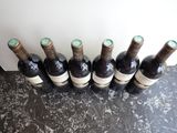 six bottles of wine are lined up in a row on a table