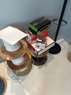 une pile de fils posée sur une table à côté d'une lampe
