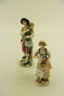 deux figurines représentant des personnes debout l'une à côté de l'autre