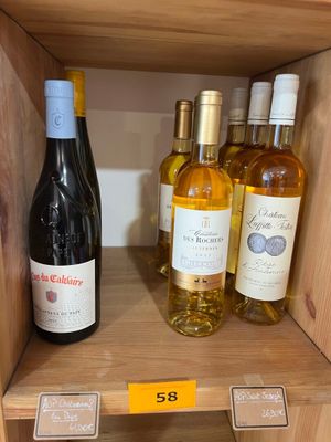 de nombreuses bouteilles de vin sur une étagère dans un magasin