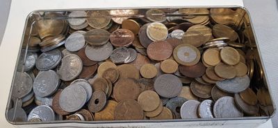 a metal container filled with coins on a table