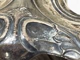 a close up of a silver vase on a table