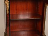 an antique wooden bookcase with a black and gold decoration