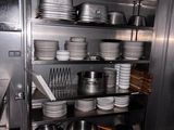 beaucoup d'assiettes et de casseroles sur les étagères de la cuisine