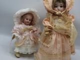 Deux poupées en porcelaine, représentant une femme et un enfant, sont placées l'une à côté de l'autre