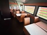 many tables and chairs in the dining car of a train