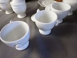 many cups and saucers sitting on a table