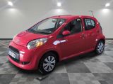 la petite voiture rouge est garée sur un sol en damier