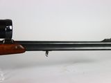 a close up of a rifle with a scope mounted on it