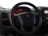 steering wheel and dashboard of a black pickup truck with a red dash light