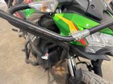 a close up of a green motorcycle parked on the street