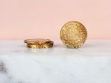 two gold coins sitting on top of a marble counter top