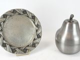 une assiette en argent et une poire en argent, l'une à côté de l'autre