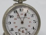 a silver pocket watch that is on a white surface