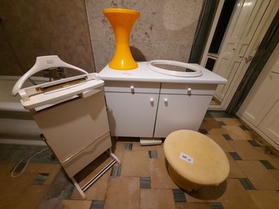un vase jaune posé sur un évier, à côté d'une cuisinière