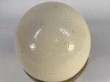 beige and white ceramic ball with a gold rim on a white surface