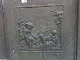 a plaque on the side of a building with a man and a dog