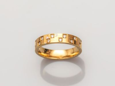 gros plan d'une bague en or avec des diamants sur une surface blanche