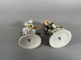 pair of porcelain figurines of mice with flowers and leaves