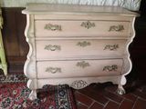 a dresser with a bed and a rug on the floor
