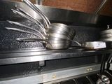 pots and pans are stacked on a shelf in a kitchen