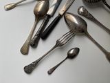 a lot of silver spoons and forks on the table