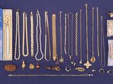 an assortment of various necklaces and bracelets laid out on a blue surface