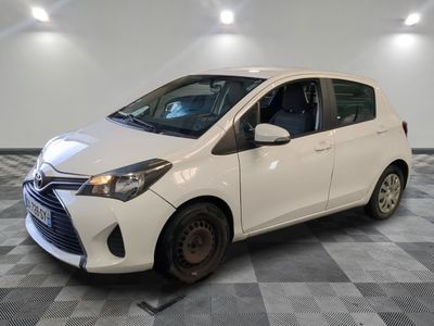 the white toyota yaris is parked on a checkered floor