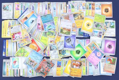 une grande collection de cartes Pokémon posées sur une surface bleue
