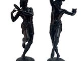 deux statues représentant un homme tenant une batte de baseball et une femme tenant une batte de baseball
