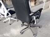 a black office chair and a white office chair in a warehouse
