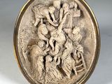 une assiette en argent ornée d'un relief représentant un groupe de personnes