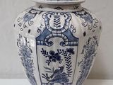 a blue and white vase with a lid on a table